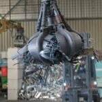 Clamshell grabbing scrap in a scrap metal recycling plant