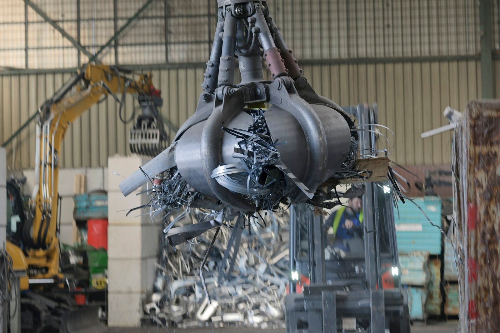 Clamshell grabbing scrap in a scrap metal recycling plant